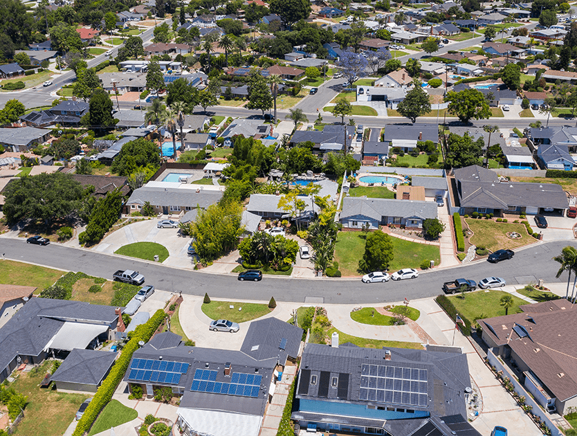 Aerial photo of suburban homes with solar panels on roofs
